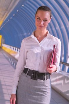 Portrait of beautiful young business woman with red folder