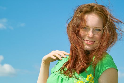 Beautiful lady in green smiling over sky