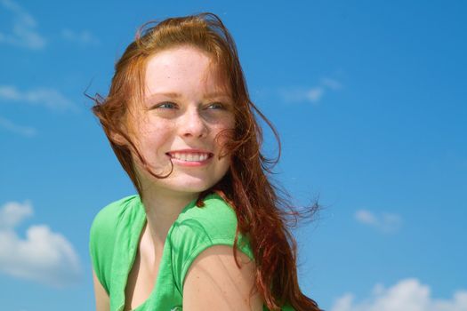 Beautiful lady in green smiling over sky