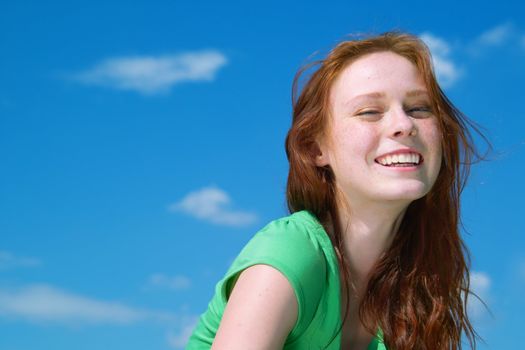 Beautiful lady in green smiling over sky