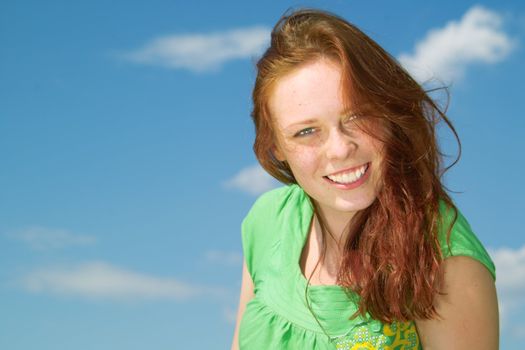 Beautiful lady in green smiling over sky