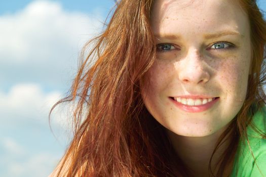 Beautiful lady in green smiling over sky