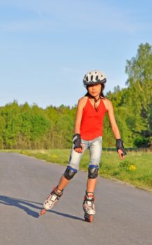 A young girl is out skating on her inlines.