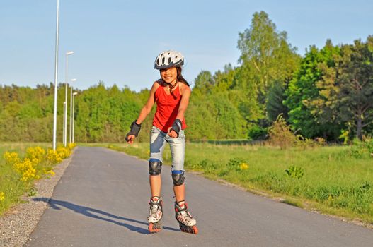 A young girl is skating on her inlines.