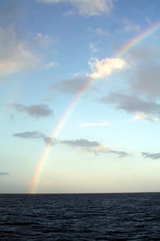 A rainbow stretching over the Pacific Ocean.