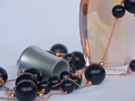 The image of a bottle with perfumery water and the scattered thread of a beads