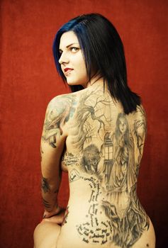 Woman with many tattoos on her back and arms