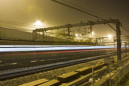 Rails by night with reflecting neon light.