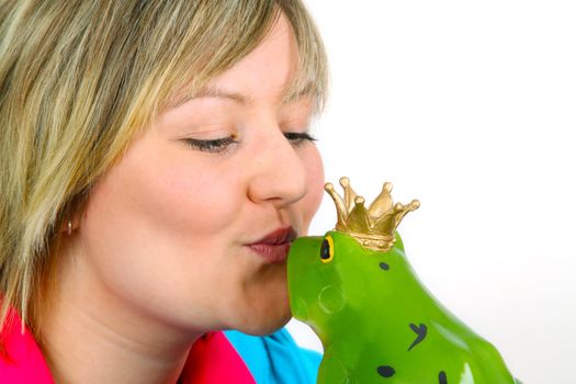 Young woman kissing a frog prince on white background. Shot in studio.