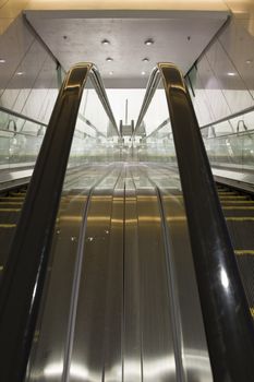 It is a close up with escalator in a building.