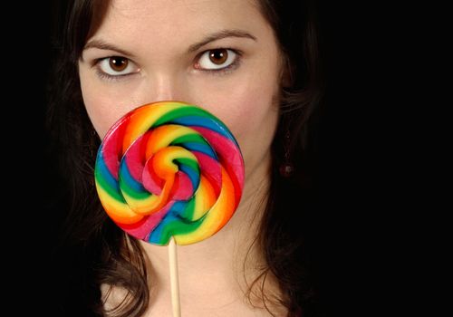 Beautiful female with a large colourful lollipop.
