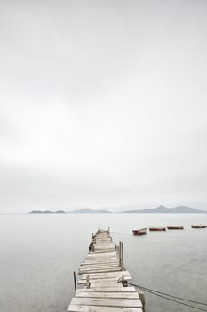 Looking over a desolate peer and a boat
