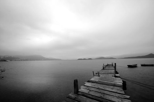 Looking over a desolate peer and a boat
