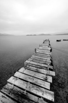 Looking over a desolate peer and a boat
