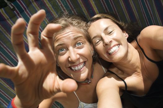 Caucasian mid-adult women being silly in hammock.