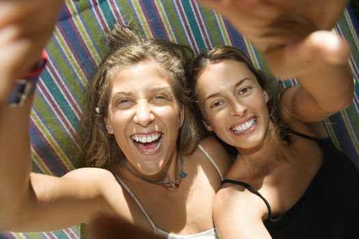Caucasian mid-adult women being silly in hammock.