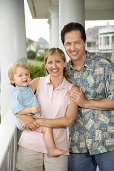 Family portrait of Caucasian mid-adult man and woman with male toddler.