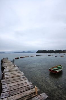 Looking over a desolate peer and a boat
