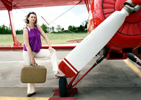 Young woman with valise around airpalne