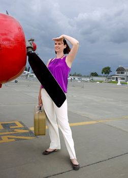 Young woman with valise around airpalne