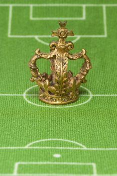 Symbol photo - crown on a soccer field. Shot in studio.