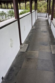 Footbridge in an Asian style garden with trees and bushes in spring bloom.