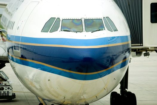 Shanghai Pudong International Airport - passanger's plane waiting at the gate, closeup photo showing nose of plane.