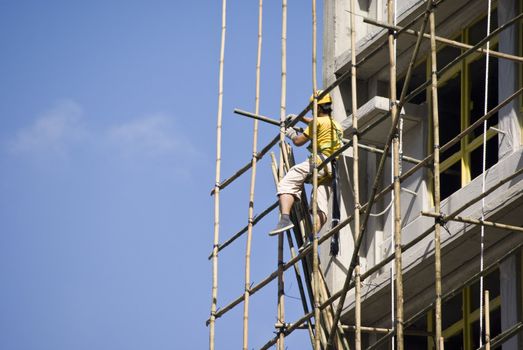 worker working at the construction side that are bamboo scaffolding