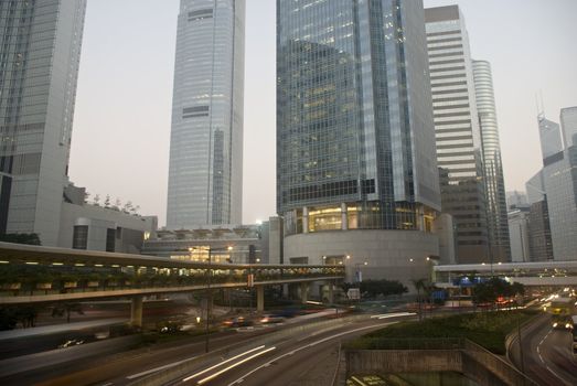 Skyscraper with traffic light and cars motion blurred in Hong Kong