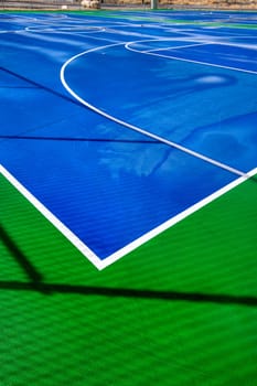 A blue and green basketball court after a good rain.