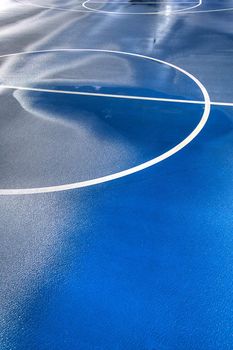 A blue and green basketball court after a good rain.