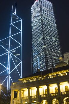 It is night scene of two skyscrapers behind a English building in Hong Kong