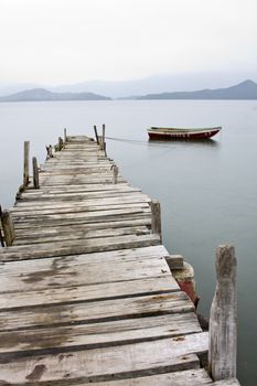 Looking over a desolate peer and a boat
