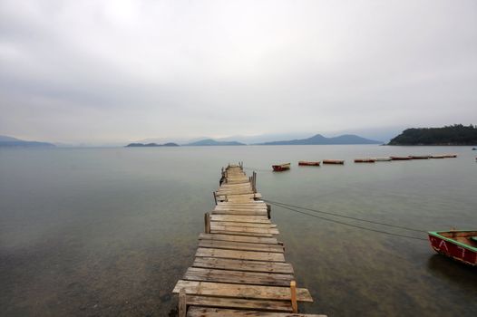 Looking over a desolate peer and a boat
