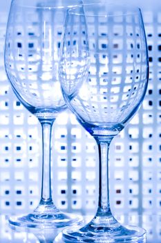 Transparent empty wine glass in a blue background.