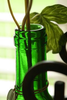 A detail of a wine bottle with vine and iron artwork.