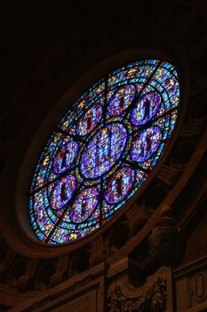 A rose window of a catholic church from the inside.