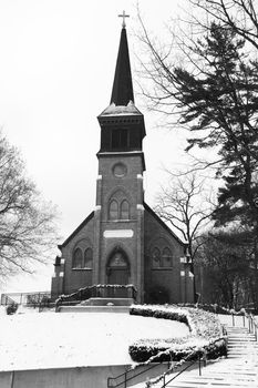 This old church sits on a hill and is blaneted by winter snow.