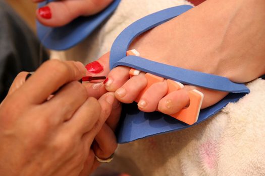 Details an person performing manicure on a woman foot