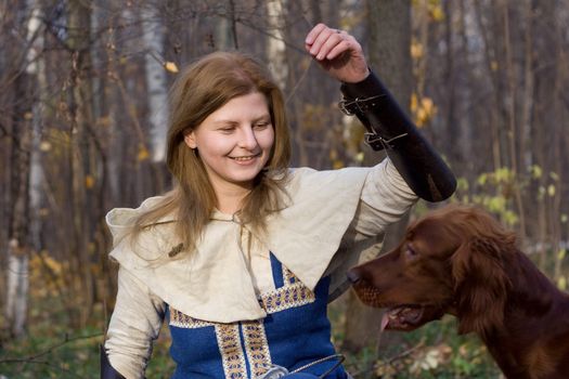 Portrait of the girl and irish setter in autumn forest.
