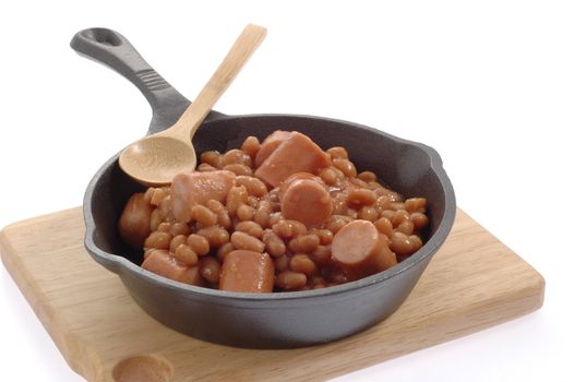 Beans and weiners in a cast iron skillet.