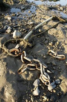 An old rusty chain on the sandy beach