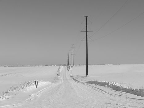 an empty rural winter road after a large snowstorm