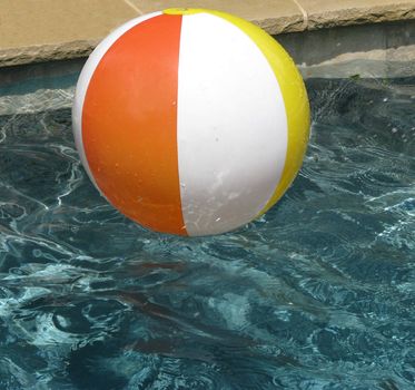 Enjoying a staycation with a beach ball in the pool.
