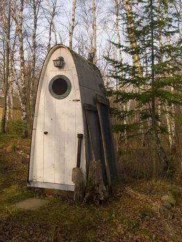 A space ship shaped outhouse in the woods of Minnesota.