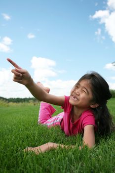 Little girl lying on grass in summer