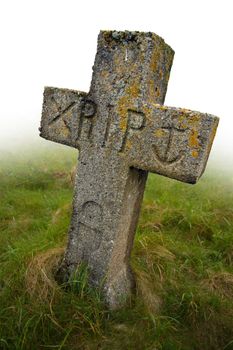 Gravestone with the initials RIP carved into it.  Ancient gravesite in South Uist, Scotland.
