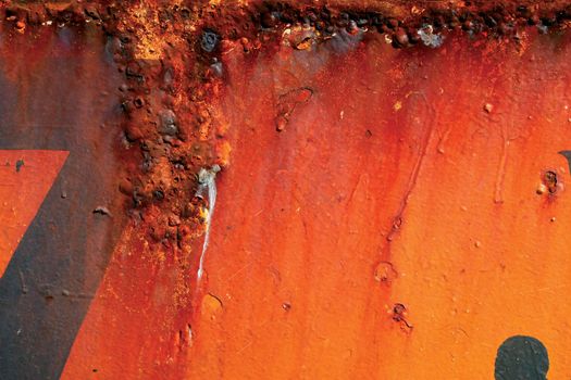 Rusting Red and orange painted metal surface.
