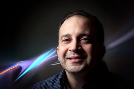 Portrait of a middle aged man over a glowing abstract background.