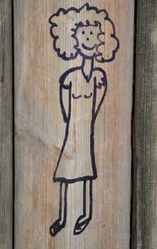 Cute marker scribble on wooden playground wall picturing a girl